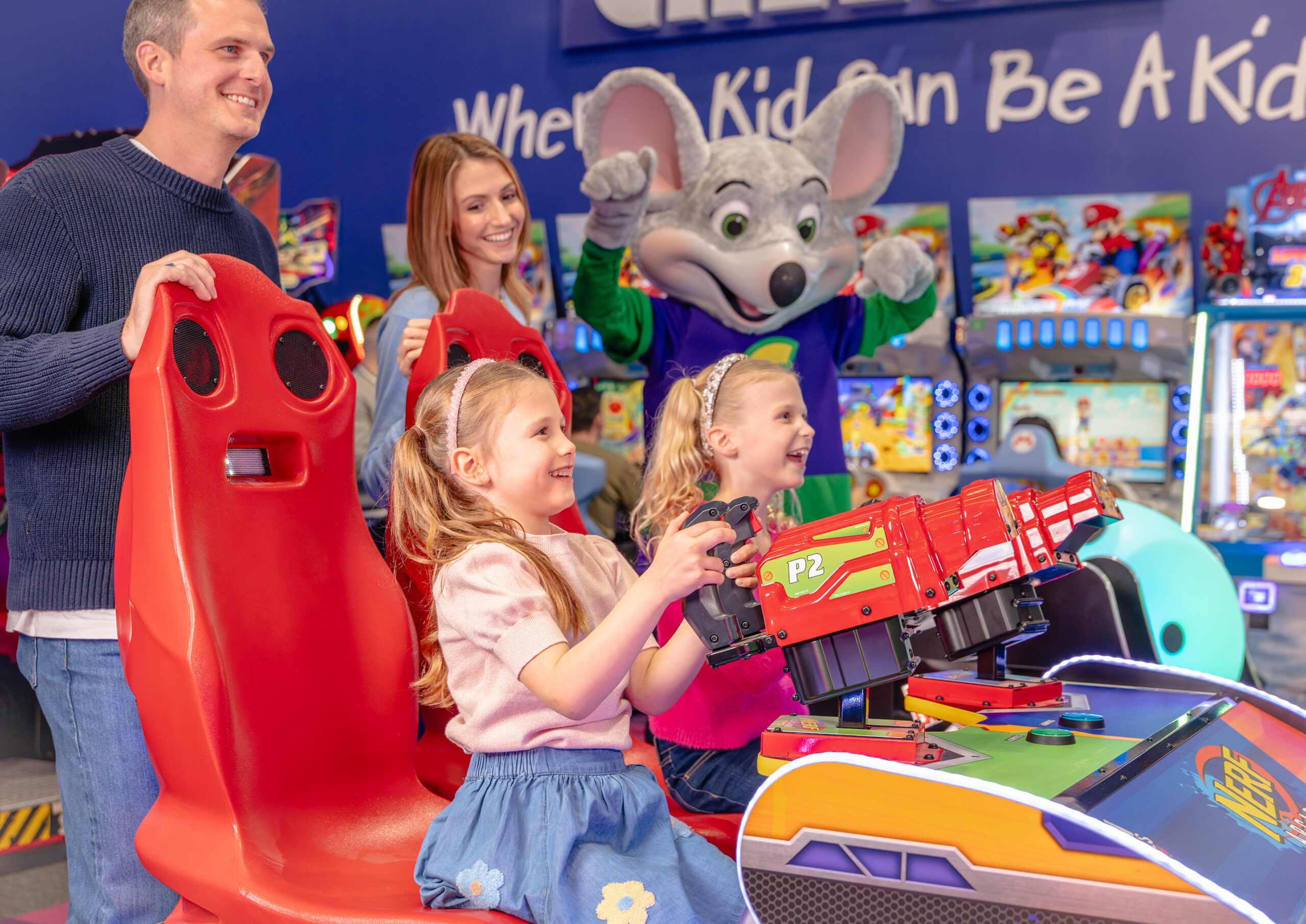 A photo of a whole family playing arcade games at the Chuck E. Cheese fun centre.