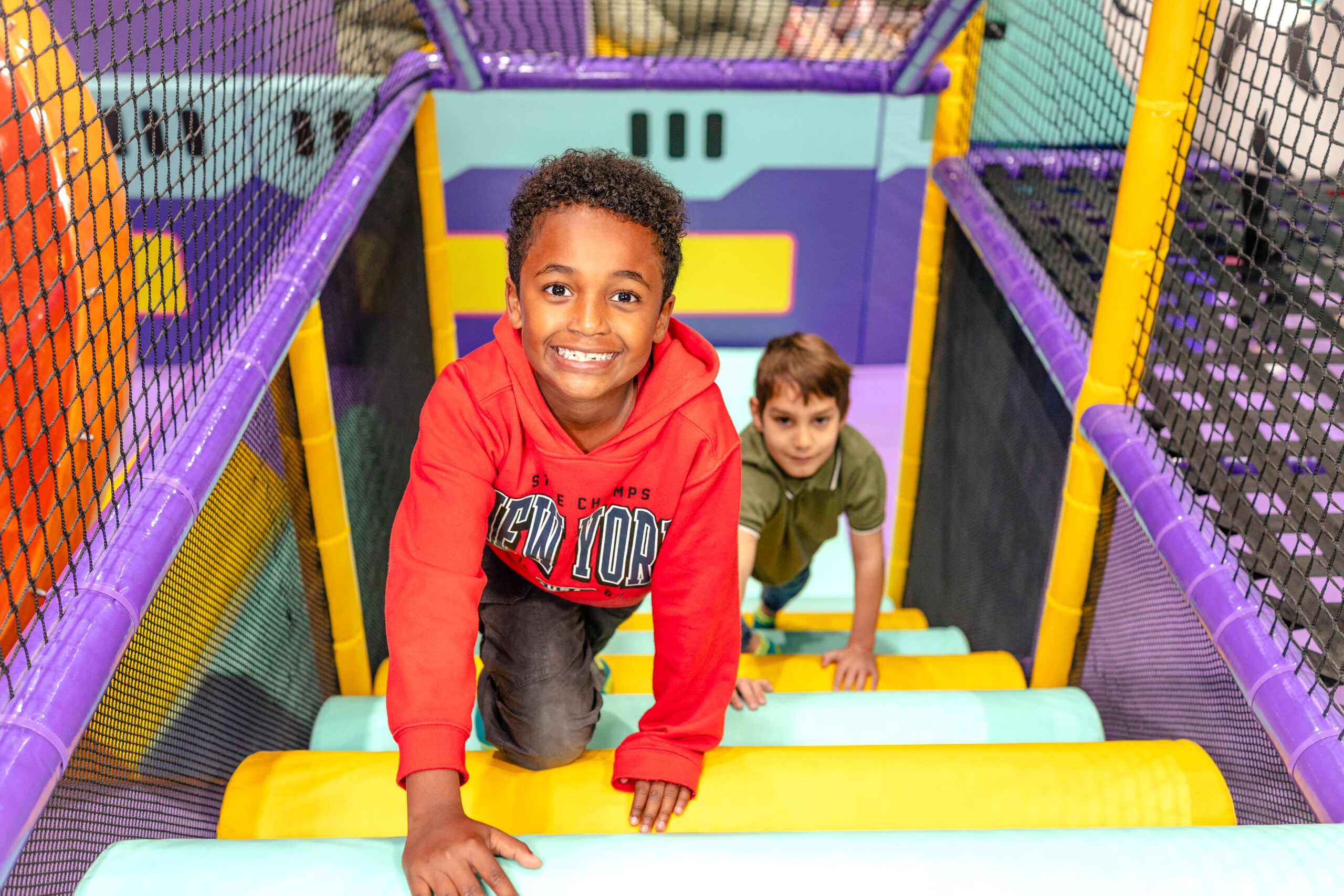 A photo of a child scrambling up the stairs of the indoor playground at Chuck E. Cheese fun centre.